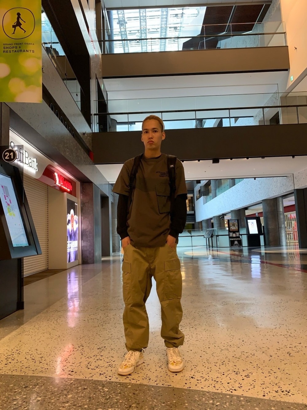 グレー系のTシャツ/カットソー、ベージュ系のカーゴパンツ、ブラック系のバックパック/リュックを着用したメンズの春コーディネートの1枚目の写真