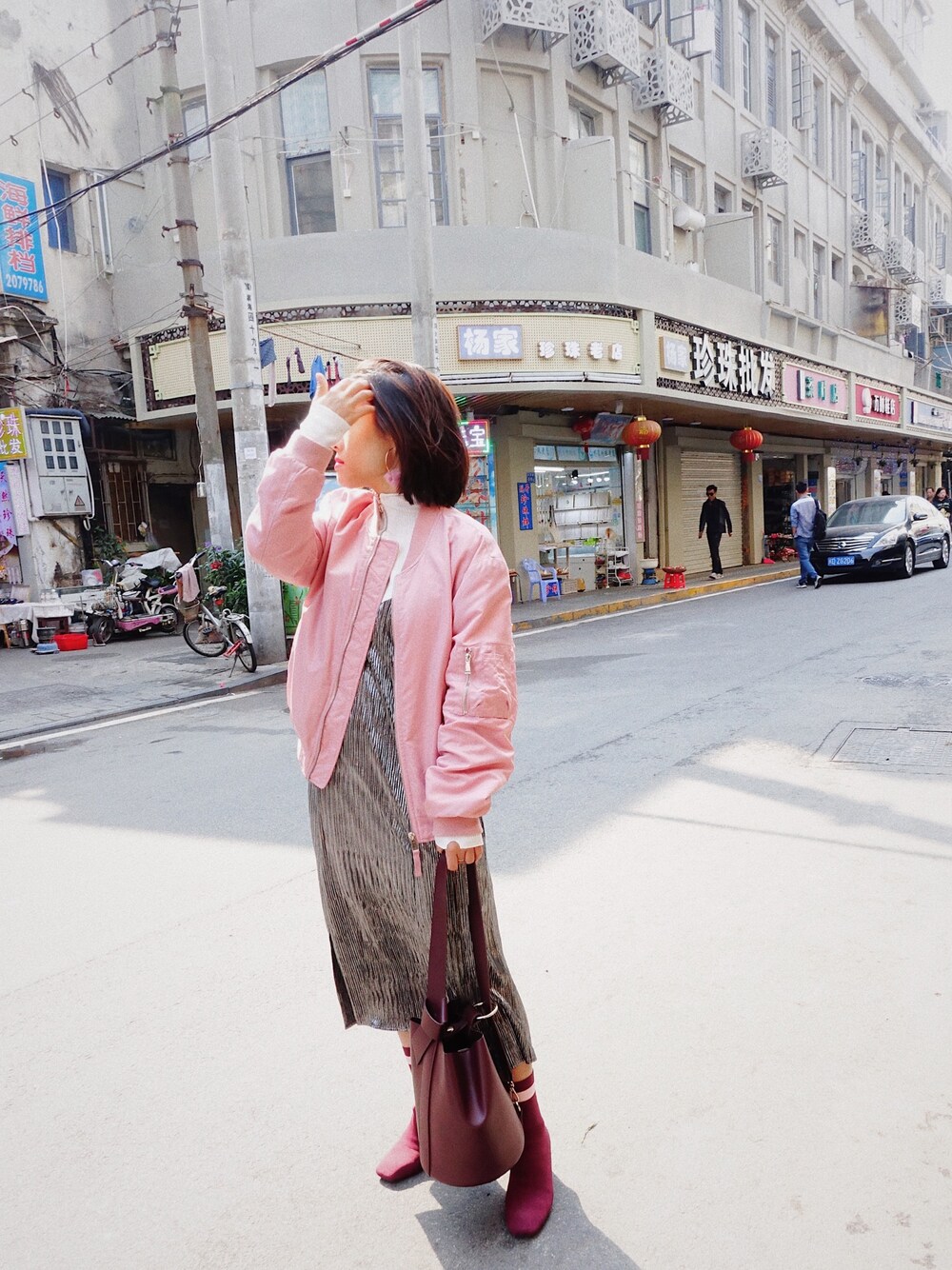 ピンク系のMA-1、シルバー系のスカート、レッド系のドラムバッグを着用したレディースの冬コーディネートの1枚目の写真