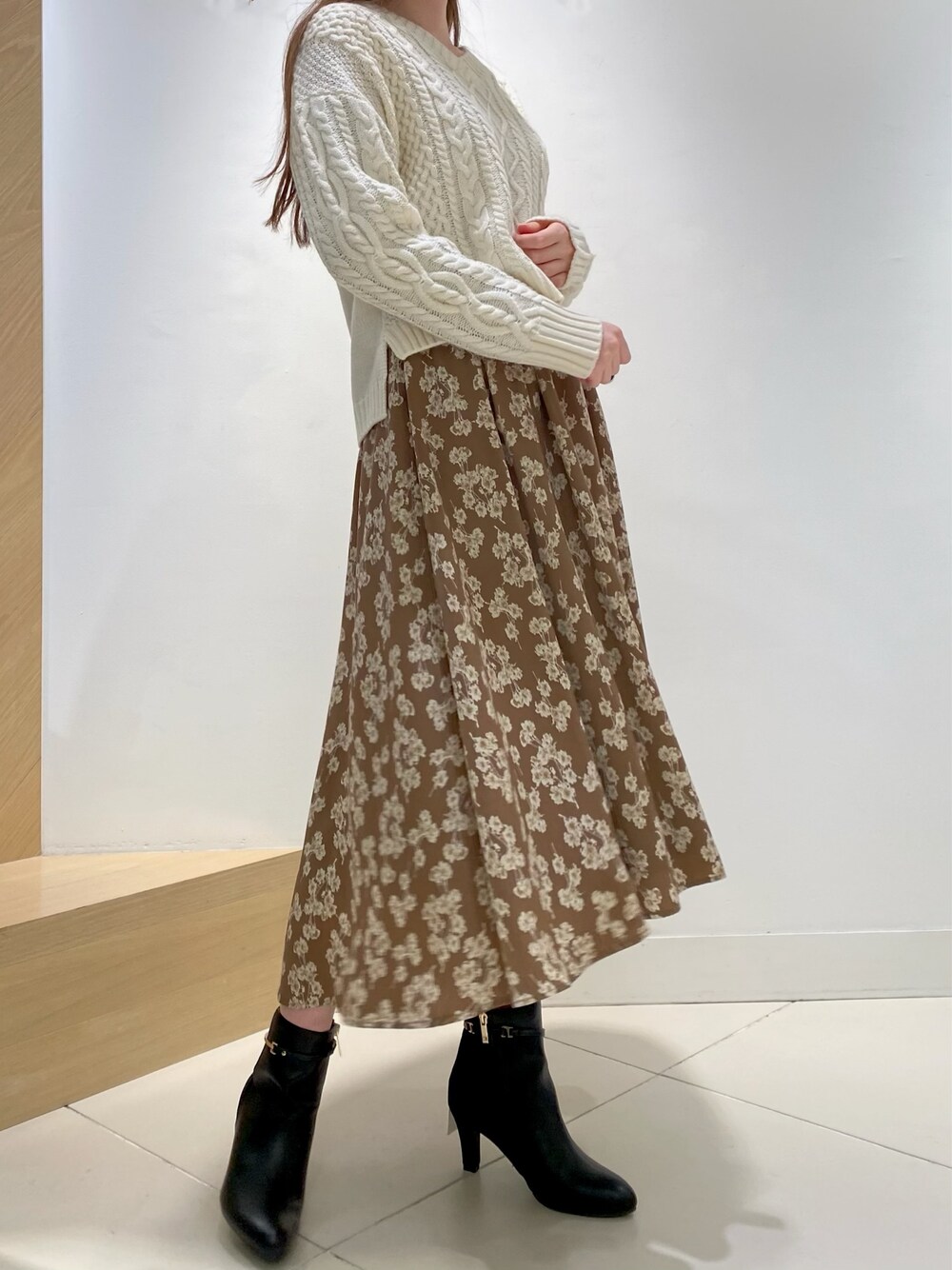 ブラウン系のワンピース、ホワイト系のニット/セーターを着用したレディースの冬コーディネートの1枚目の写真