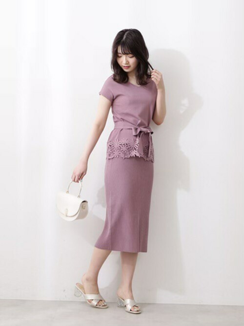 ピンク系のワンピース、ホワイト系のショルダーバッグを着用したレディースの春コーディネートの1枚目の写真