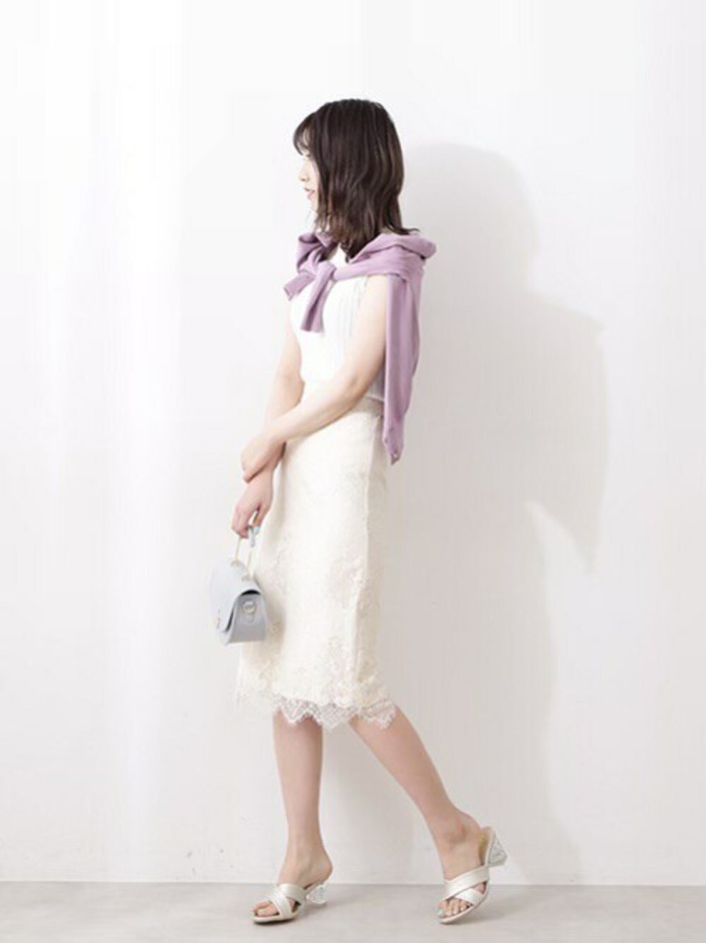 ホワイト系のニット/セーター、パープル系のカーディガン/ボレロ、ホワイト系のスカートを着用したレディースの春コーディネートの1枚目の写真