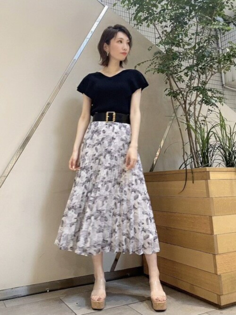 ブラック系のニット/セーター、グレー系のスカートを着用したレディースの夏コーディネートの1枚目の写真