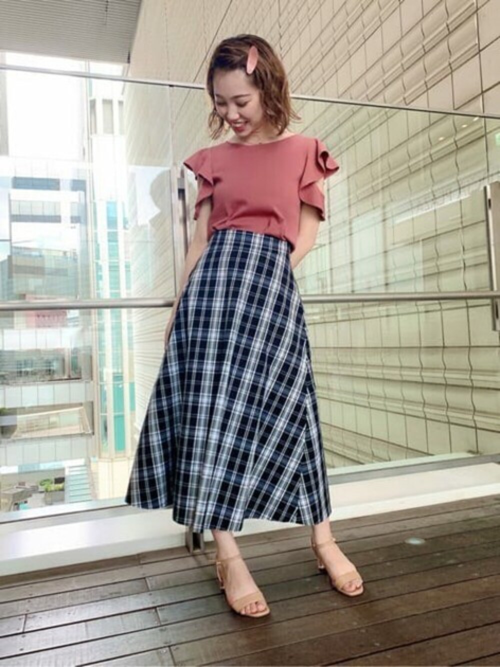 ブラック系のスカート、ピンク系のニット/セーターを着用したレディースの夏コーディネートの1枚目の写真