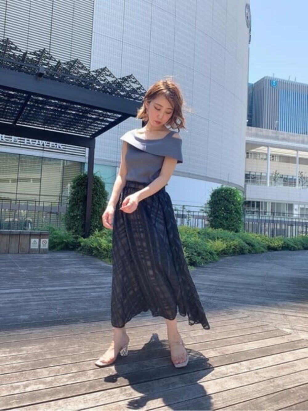 ブラック系のスカート、グレー系のニット/セーターを着用したレディースの夏コーディネートの1枚目の写真