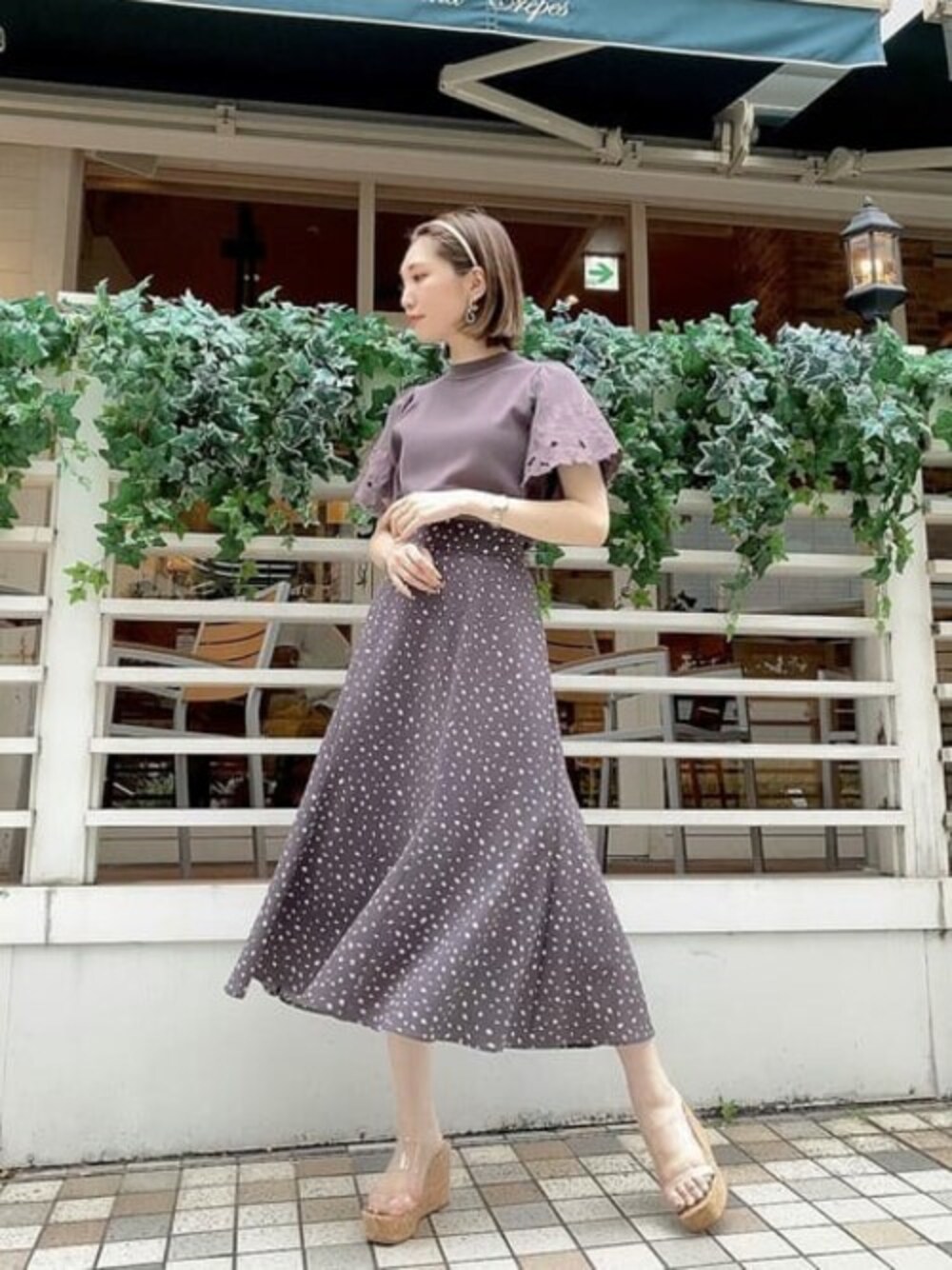 グレー系のニット/セーター、ブラウン系のスカートを着用したレディースの夏コーディネートの1枚目の写真