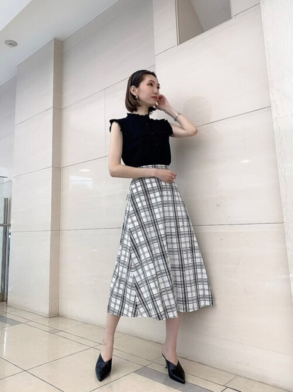 ブラック系のシャツ/ブラウス、ホワイト系のスカートを着用したレディースの夏コーディネートの1枚目の写真