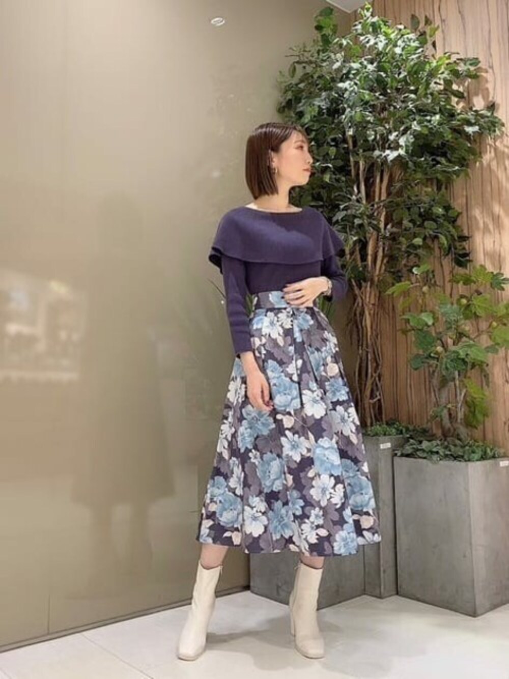 ブルー系のニット/セーター、ブルー系のスカートを着用したレディースの秋コーディネートの1枚目の写真