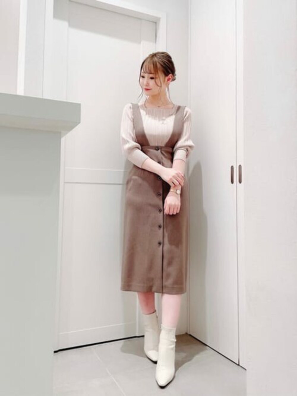 ホワイト系のニット/セーター、ブラウン系のワンピースを着用したレディースの秋コーディネートの1枚目の写真