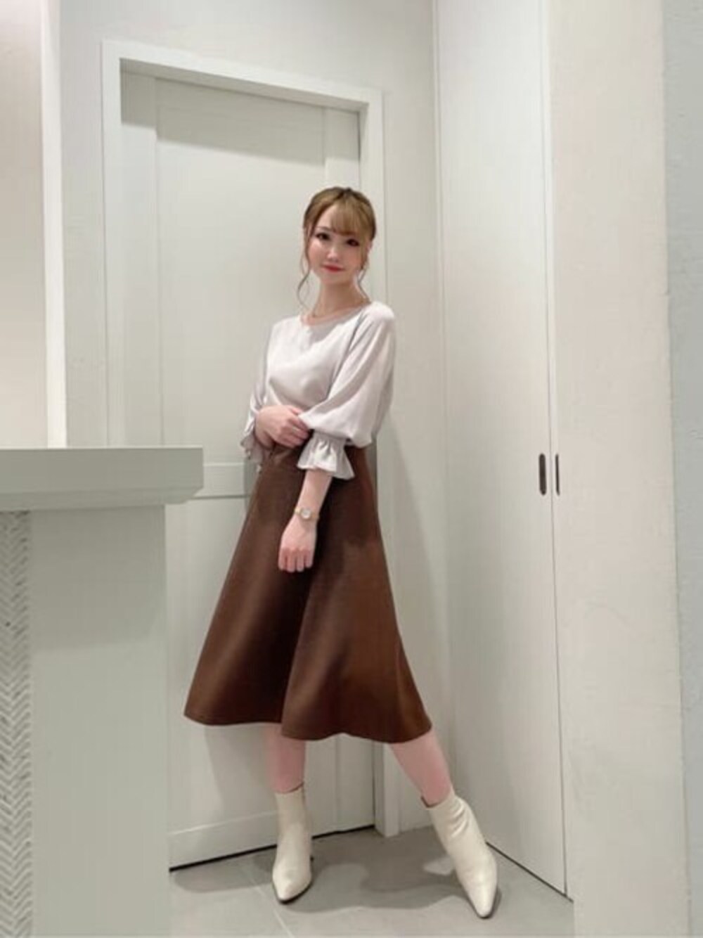 グレー系のシャツ/ブラウス、ブラウン系のスカートを着用したレディースの秋コーディネートの1枚目の写真