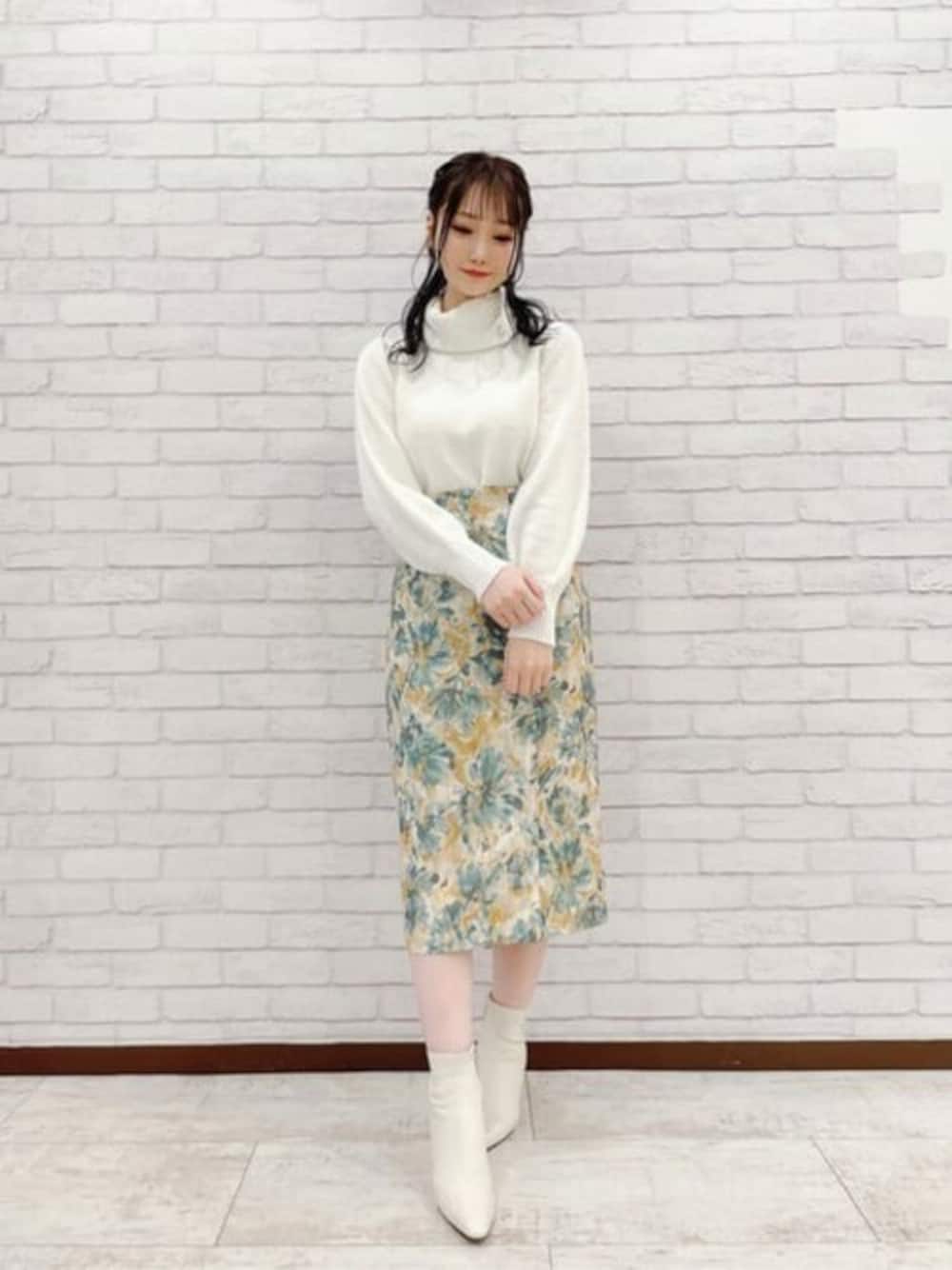 ホワイト系のニット/セーター、グリーン系のスカートを着用したレディースの秋コーディネートの1枚目の写真