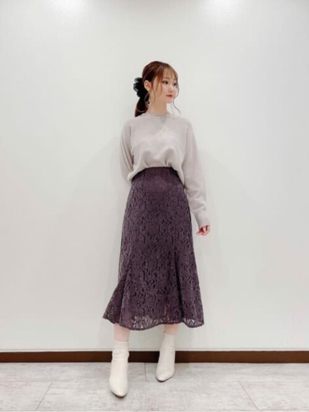 ピンク系のニット/セーター、パープル系のスカートを着用したレディースの秋コーディネートの1枚目の写真