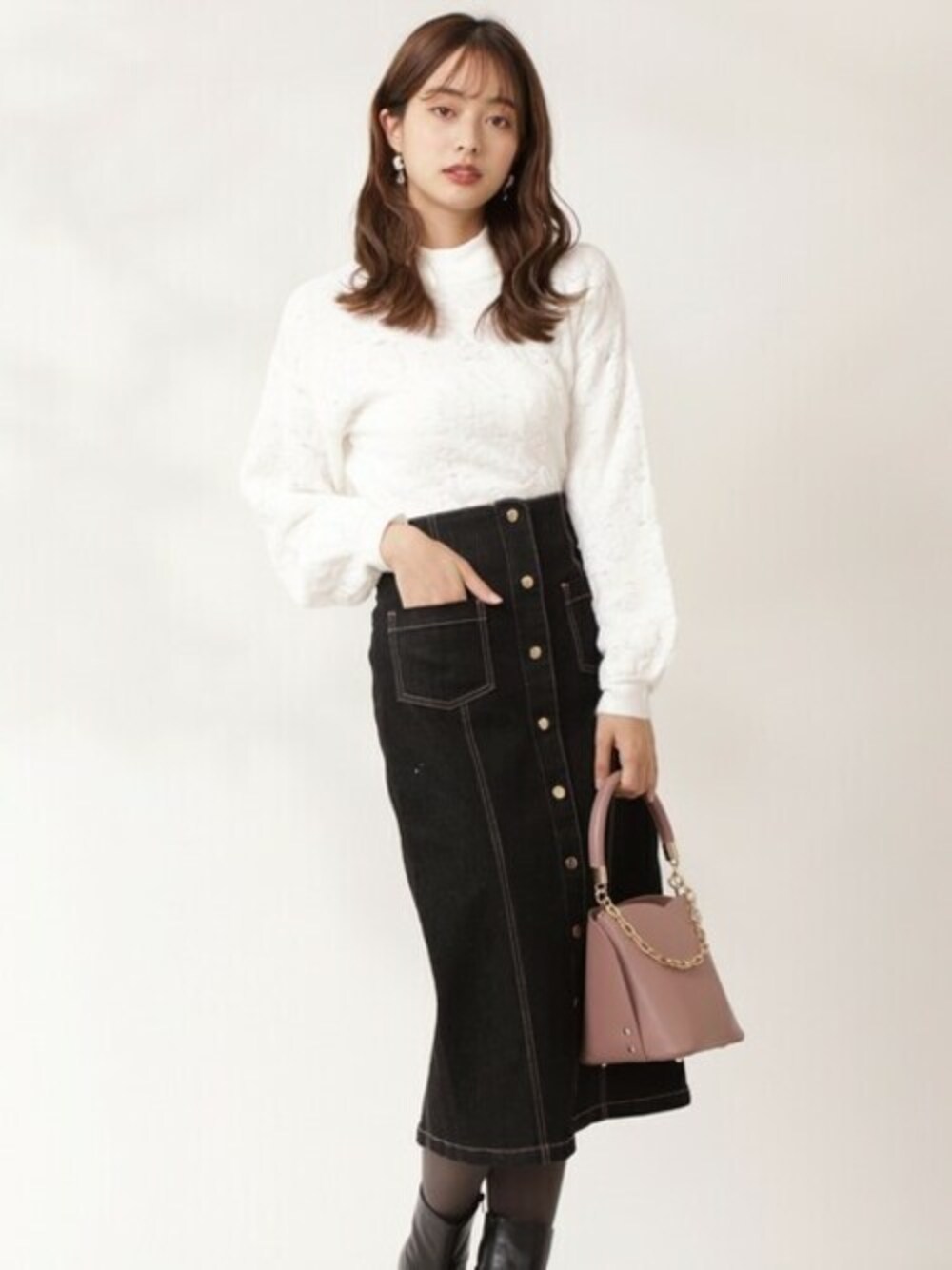 ブラック系のスカート、ホワイト系のニット/セーターを着用したレディースの冬コーディネートの1枚目の写真