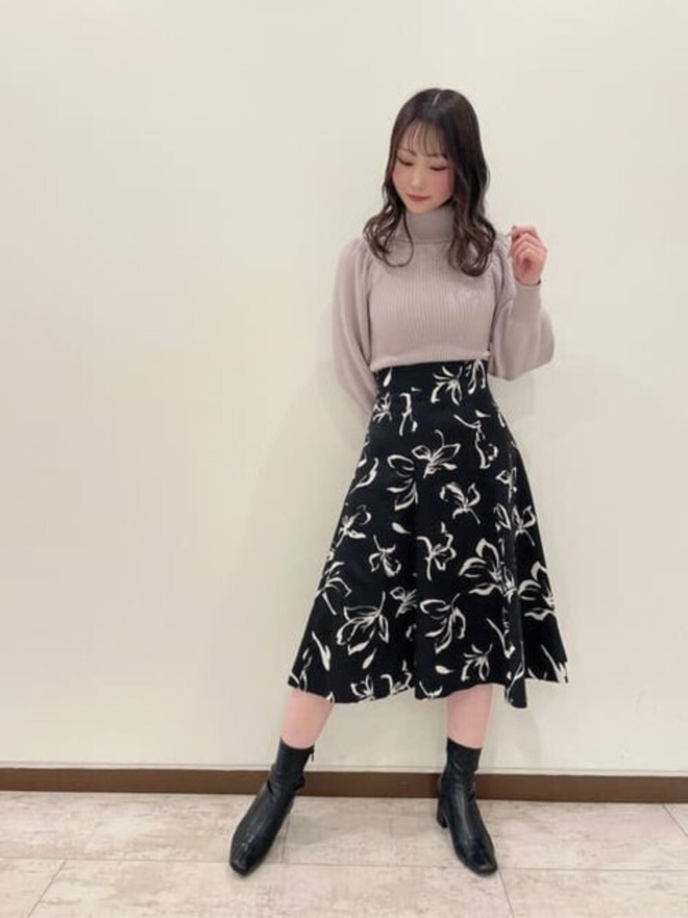 グレー系のニット/セーター、ブラック系のスカートを着用したレディースの冬コーディネートの1枚目の写真