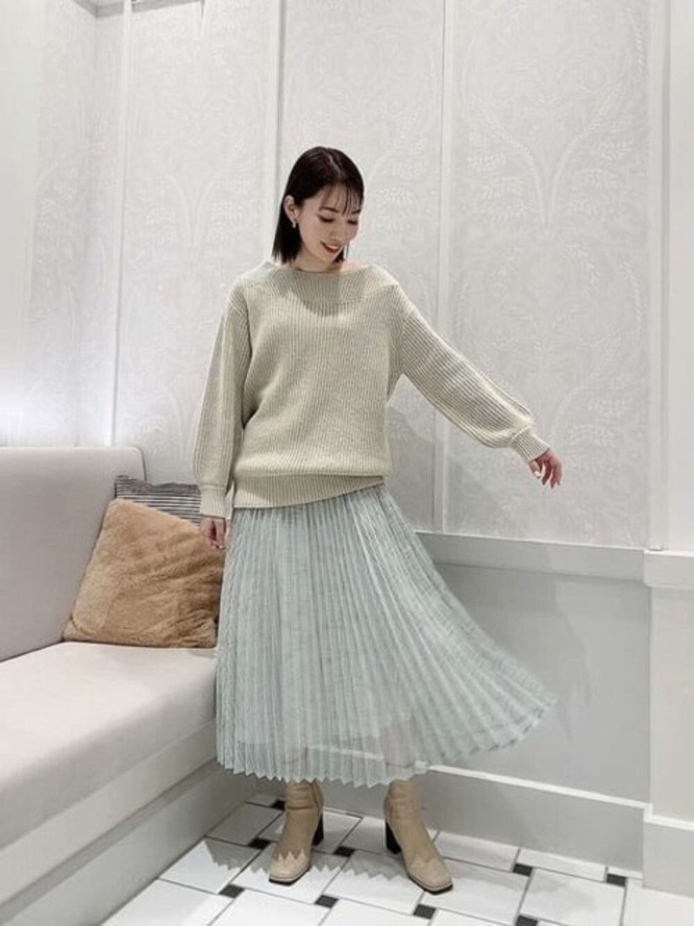 グリーン系のニット/セーター、グリーン系のスカートを着用したレディースの冬コーディネートの1枚目の写真