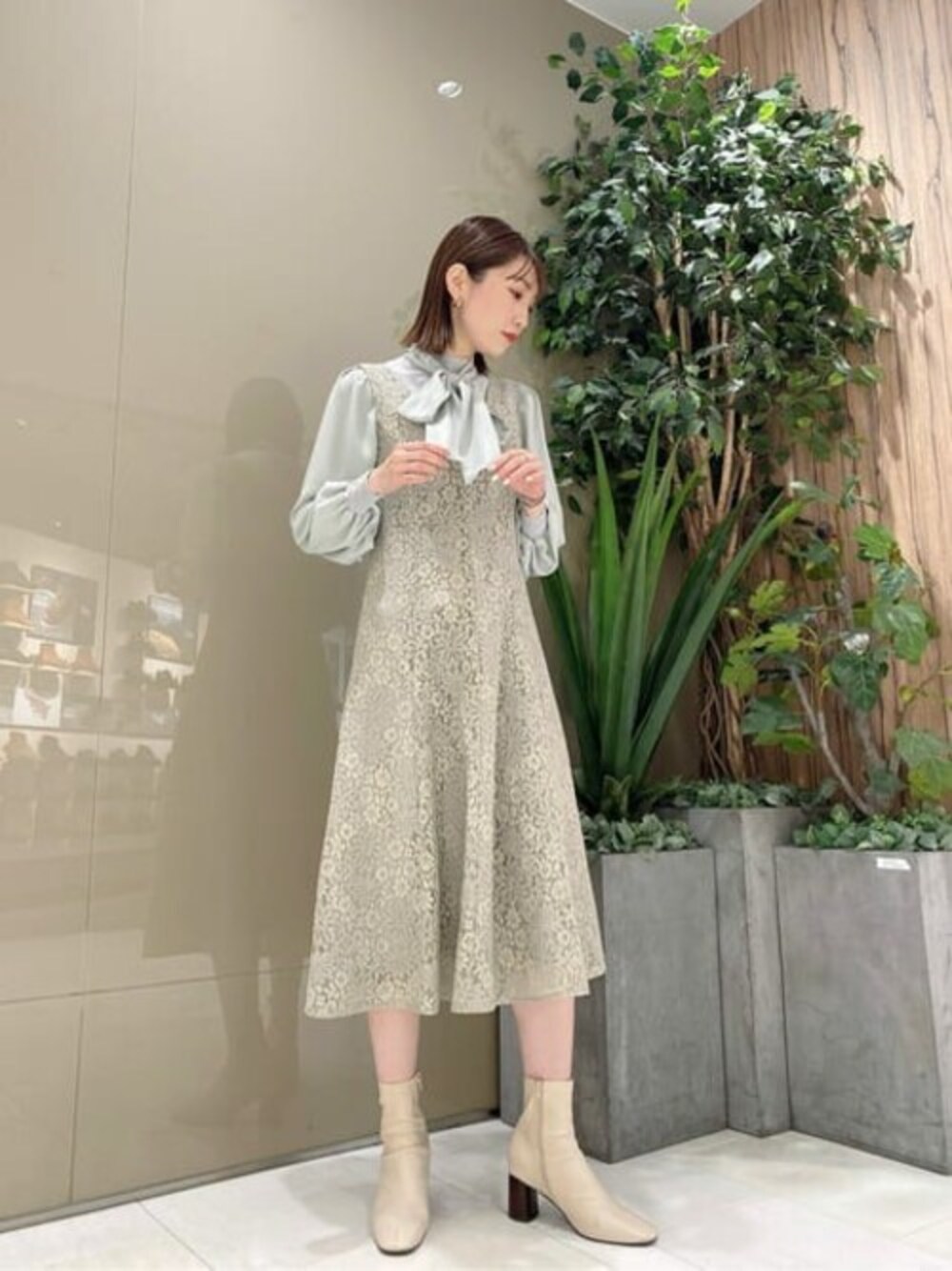 グリーン系のニット/セーター、グリーン系のワンピースを着用したレディースの冬コーディネートの1枚目の写真