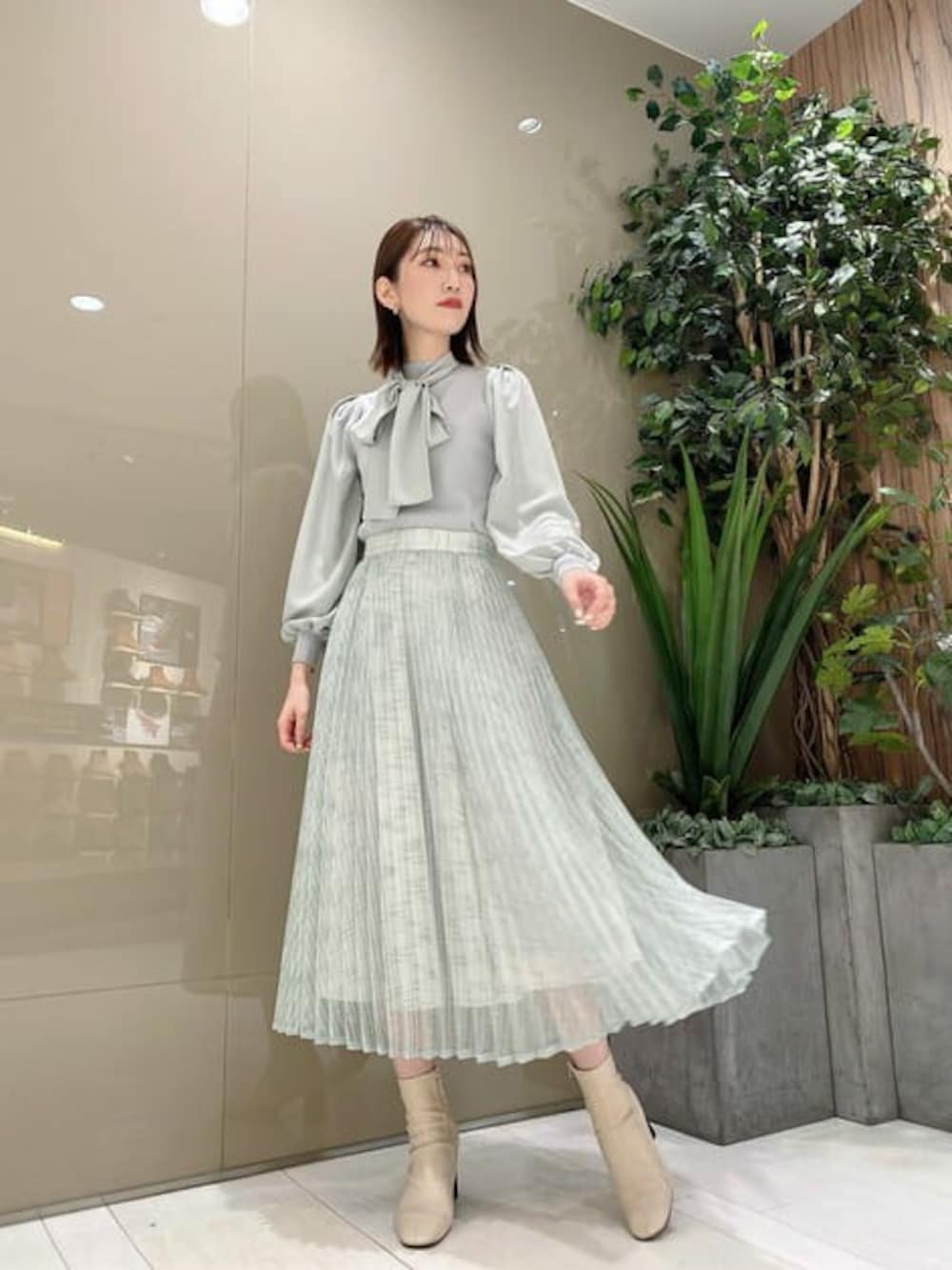 グリーン系のニット/セーター、グリーン系のスカートを着用したレディースの冬コーディネートの1枚目の写真