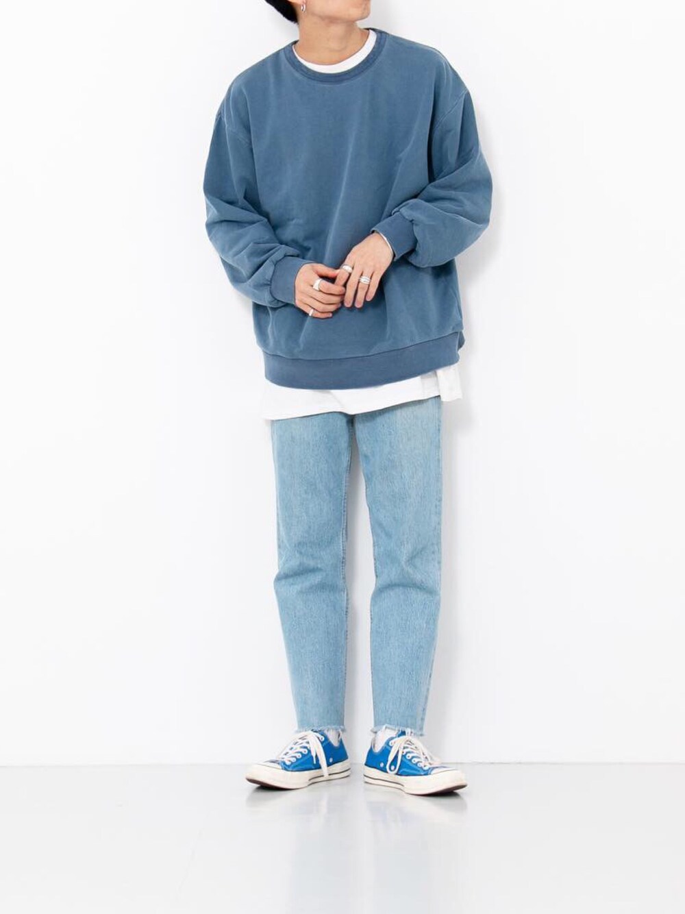 ブルー系のスウェット、ブルー系のデニムパンツ、ブルー系のスニーカーを着用したメンズの冬コーディネートの1枚目の写真