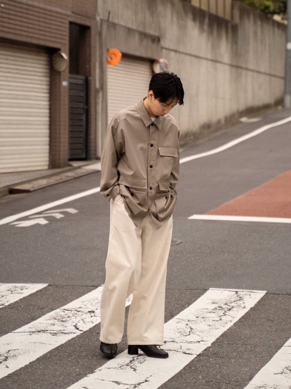 ベージュ系のジャケット/アウター、ホワイト系のパンツ、ブラック系のブーツを着用したメンズの春コーディネートの1枚目の写真