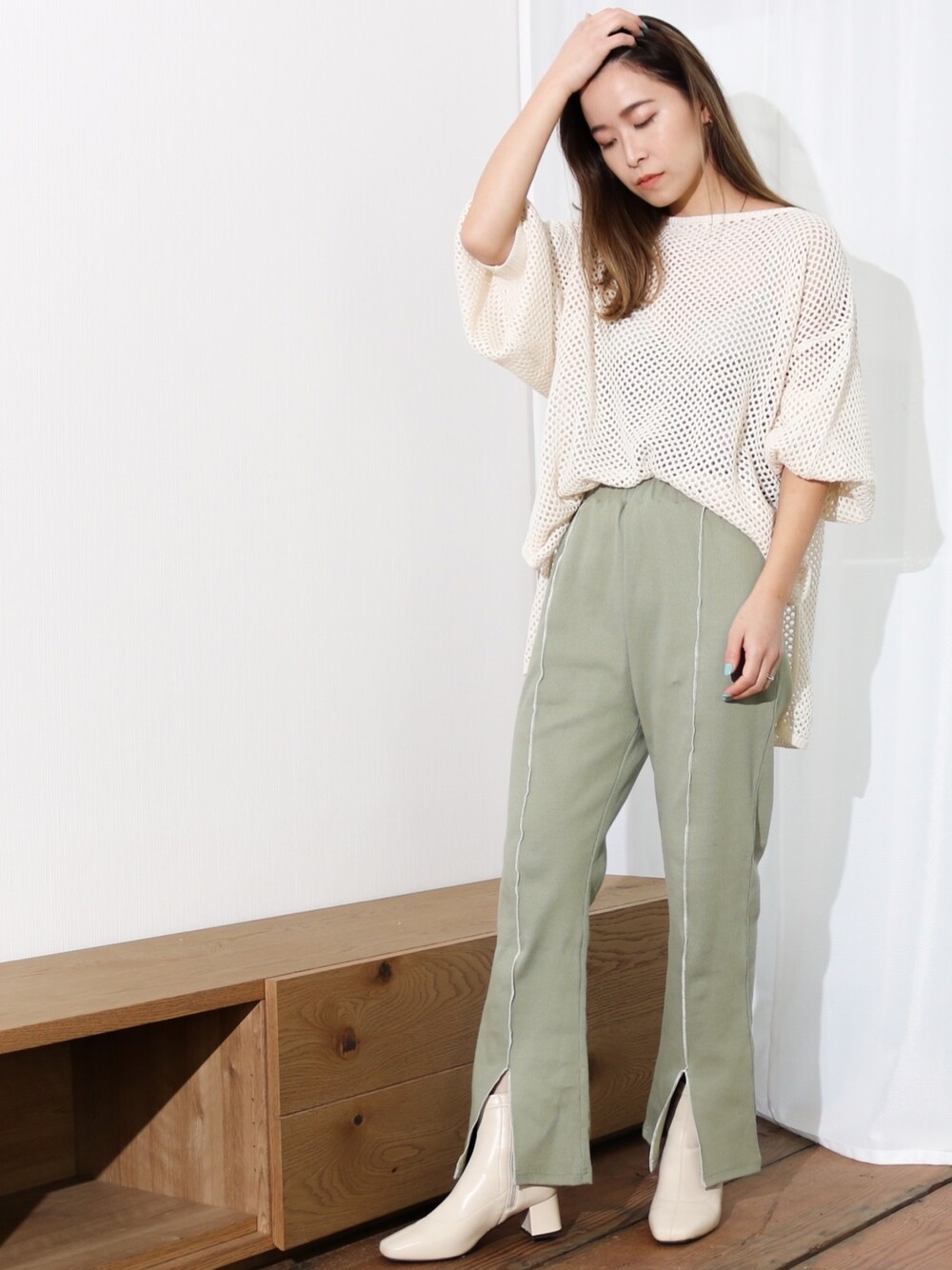 ホワイト系のニット/セーター、グリーン系のその他パンツを着用したレディースの春コーディネートの1枚目の写真