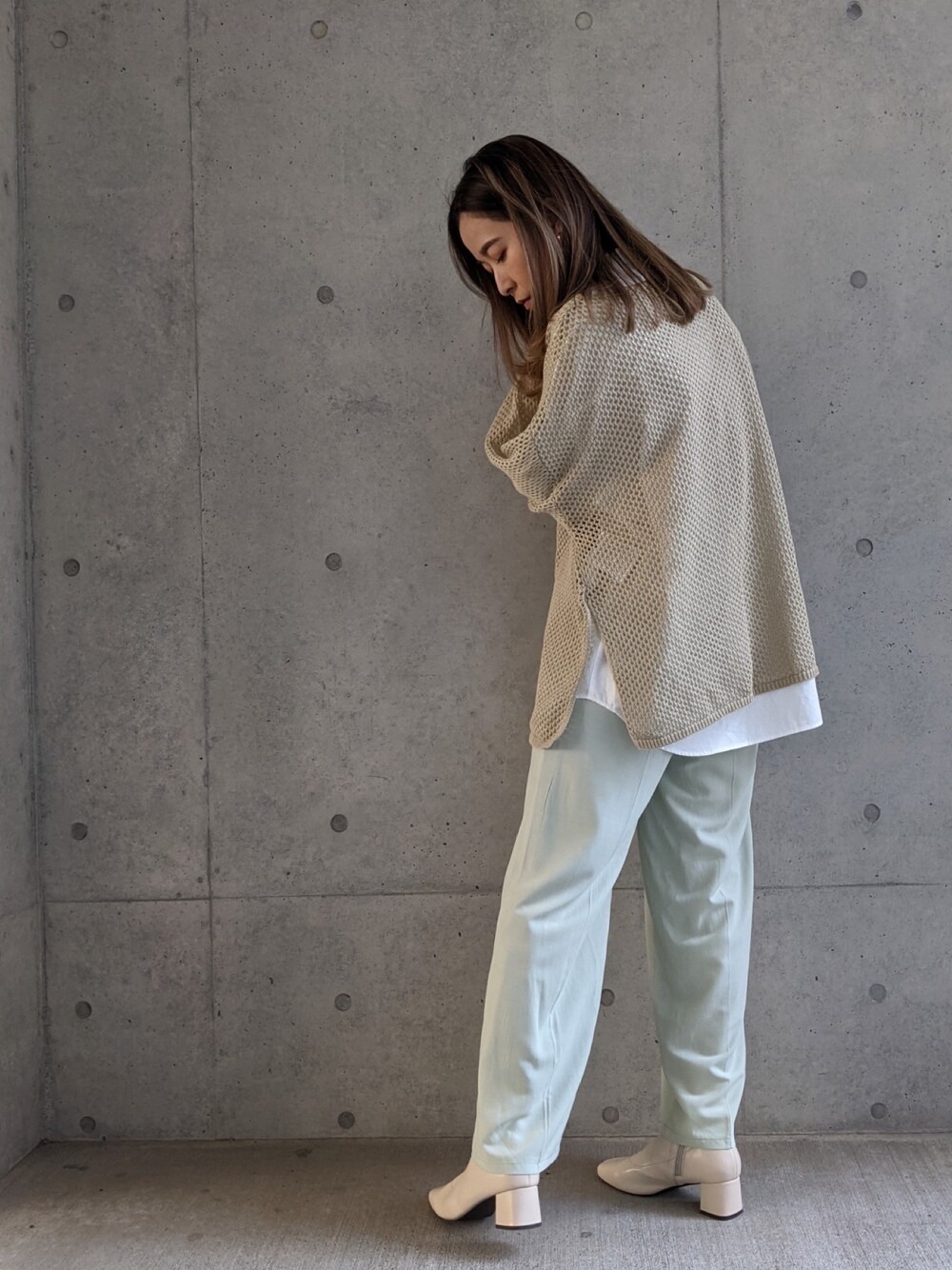 ベージュ系のニット/セーター、ベージュ系のパンツを着用したレディースの春コーディネートの1枚目の写真