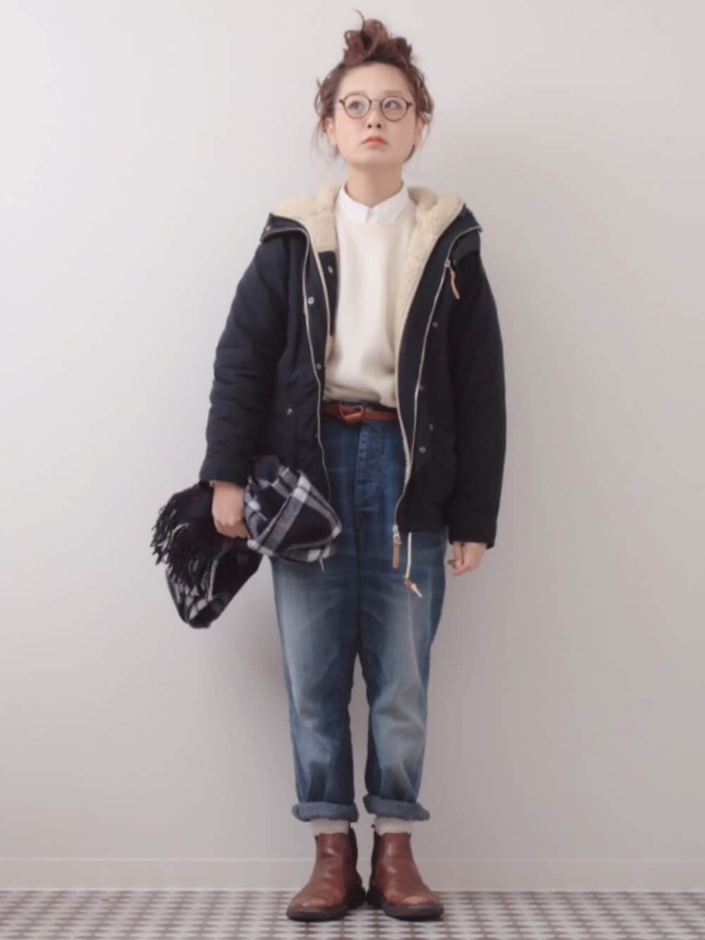 ブルー系のマウンテンパーカー、ブルー系のデニムパンツ、ブラウン系のブーツを着用したレディースの冬コーディネートの1枚目の写真