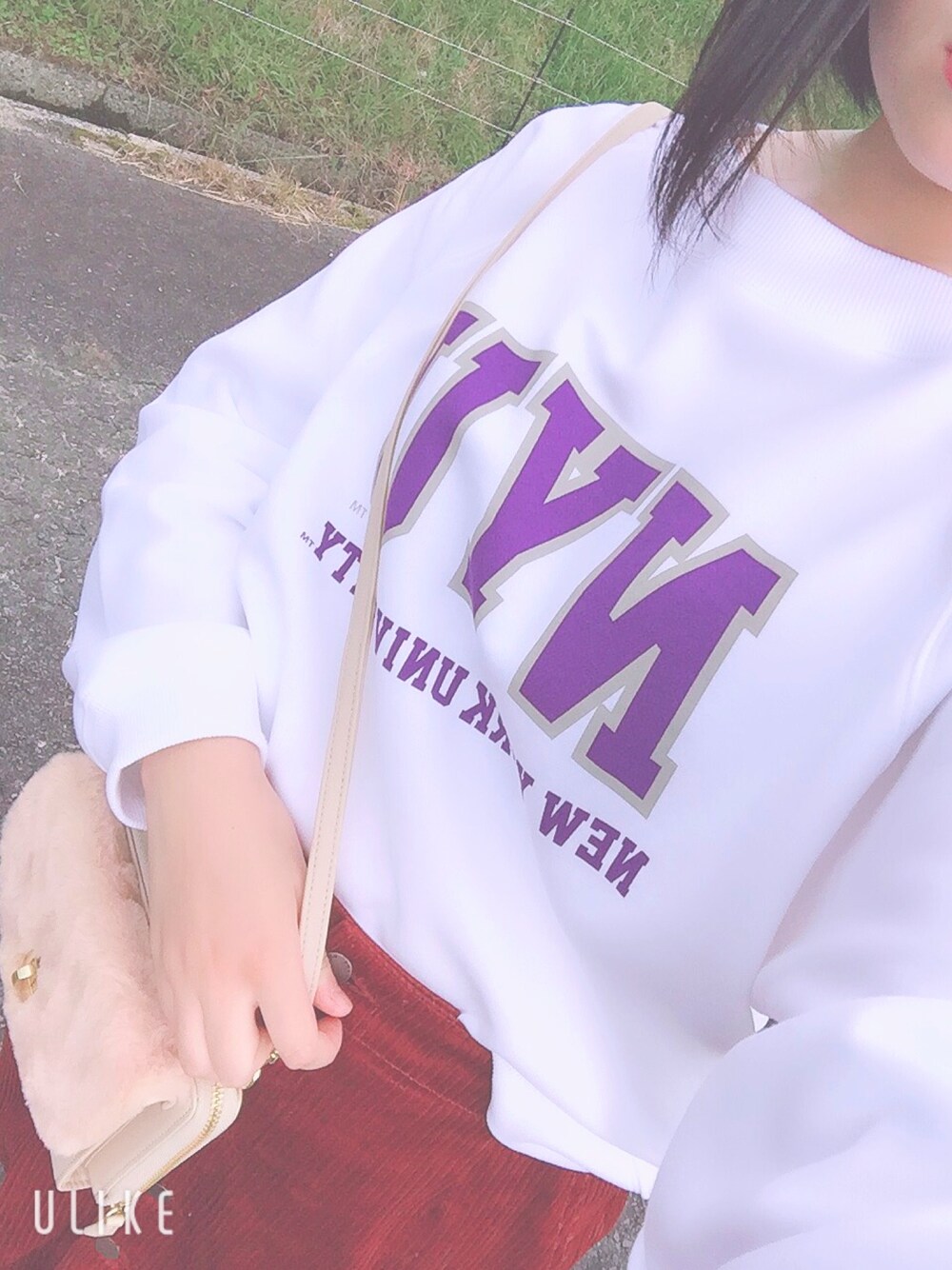 ホワイト系のスウェット、レッド系のデニムスカート、ベージュ系のショルダーバッグを着用したレディースの秋コーディネートの1枚目の写真