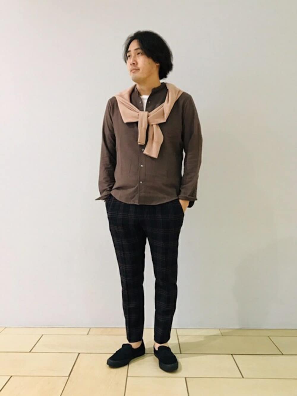 グリーン系のシャツ/ブラウス、ベージュ系のニット/セーター、ブルー系のスラックスを着用したメンズの秋コーディネートの1枚目の写真