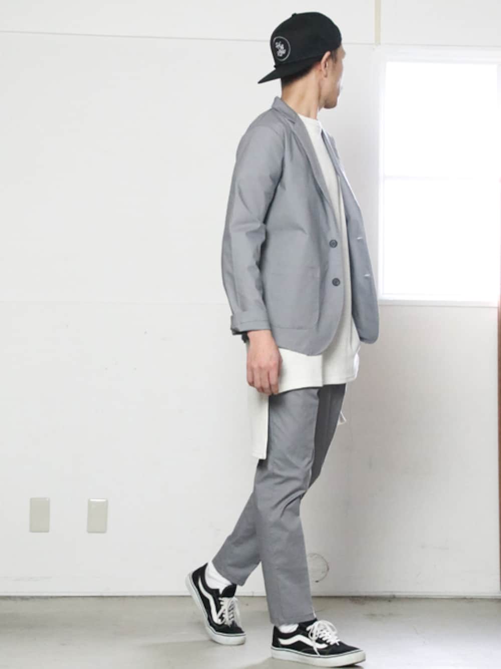 グレー系のテーラードジャケット、ホワイト系のTシャツ/カットソー、ブラック系のキャップを着用したメンズの春コーディネートの1枚目の写真