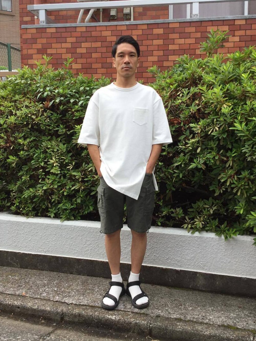 ブルー系のTシャツ/カットソー、グリーン系のカーゴパンツを着用したメンズの夏コーディネートの1枚目の写真