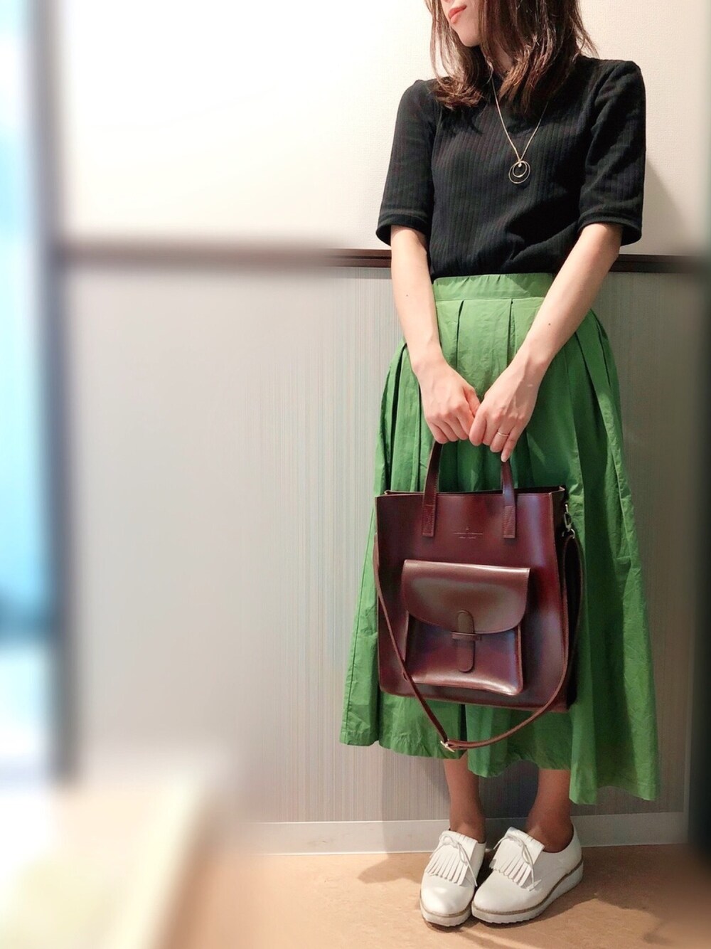 ブラック系のTシャツ/カットソー、グリーン系のスカート、レッド系のトートバッグを着用したレディースの夏コーディネートの1枚目の写真
