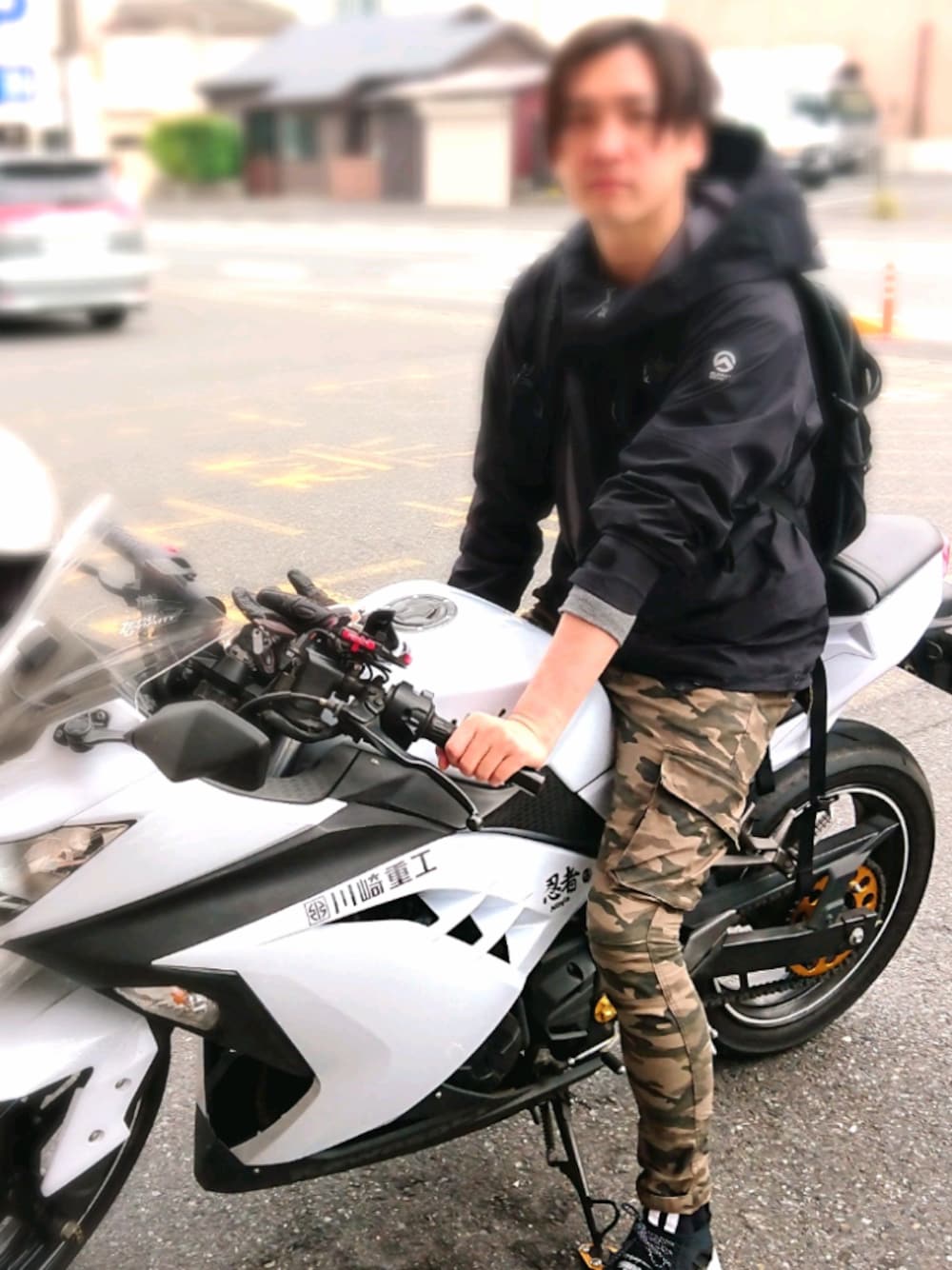 ブラック系のマウンテンパーカー、グリーン系のカーゴパンツ、ブラック系のスニーカーを着用したメンズの春コーディネートの1枚目の写真