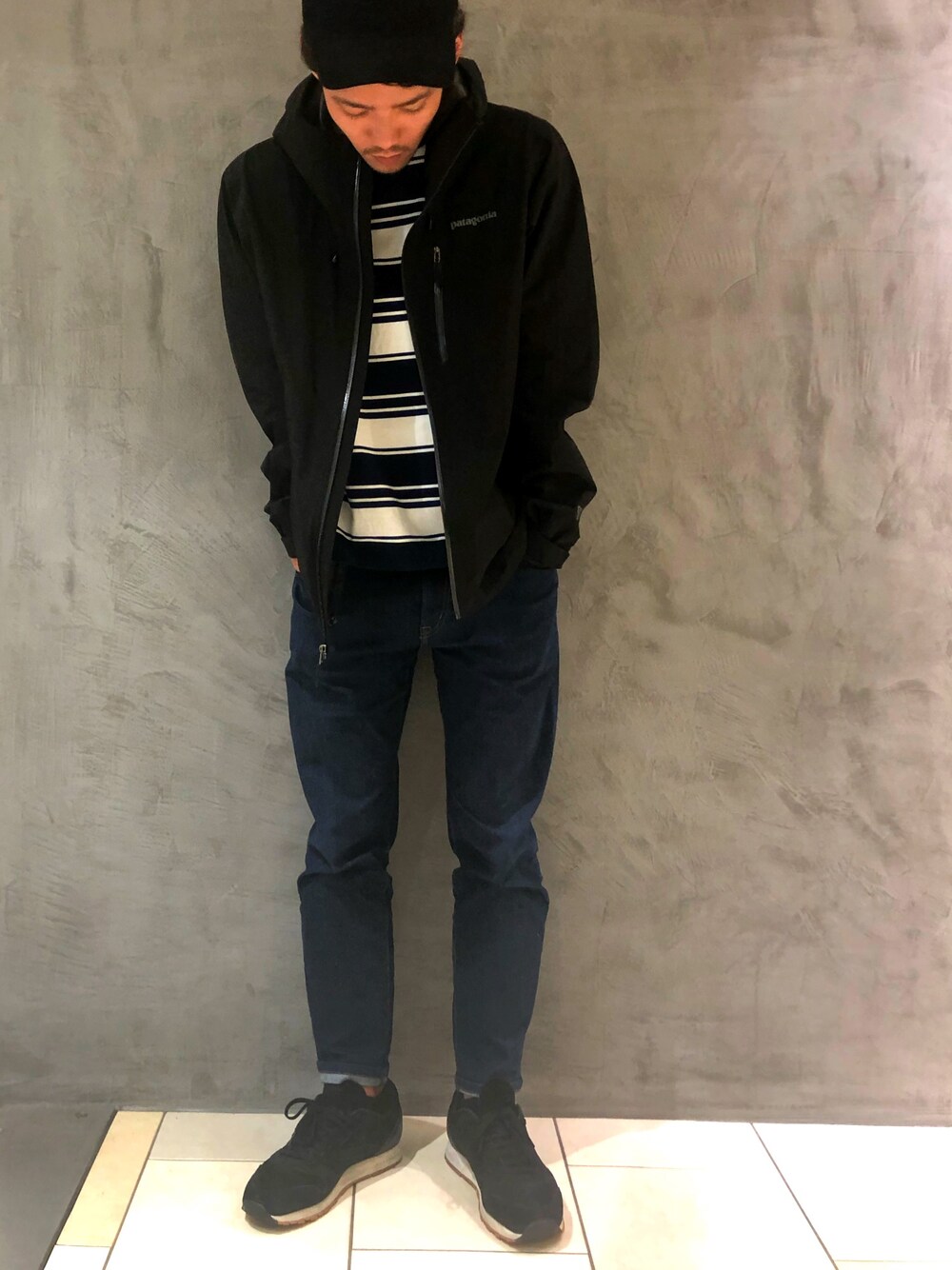 ブラック系のスニーカー、ブルー系のTシャツ/カットソー、ブラック系のマウンテンパーカーを着用したメンズの春コーディネートの1枚目の写真