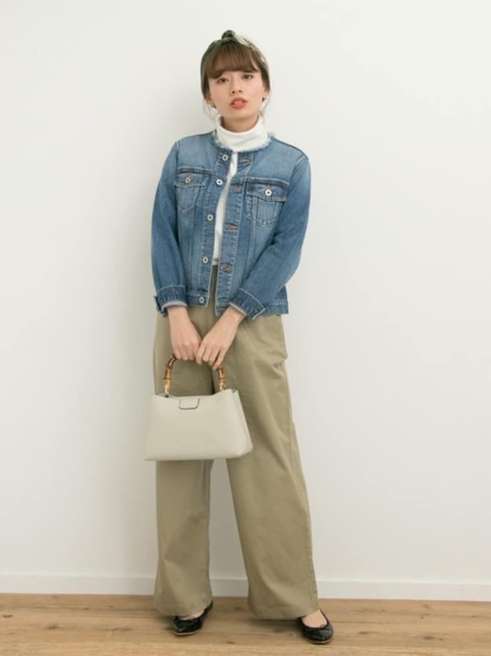 ブルー系のデニムジャケット、ブラック系のバレエシューズ、ゴールド系のピアス(両耳用)を着用したレディースの冬コーディネートの1枚目の写真