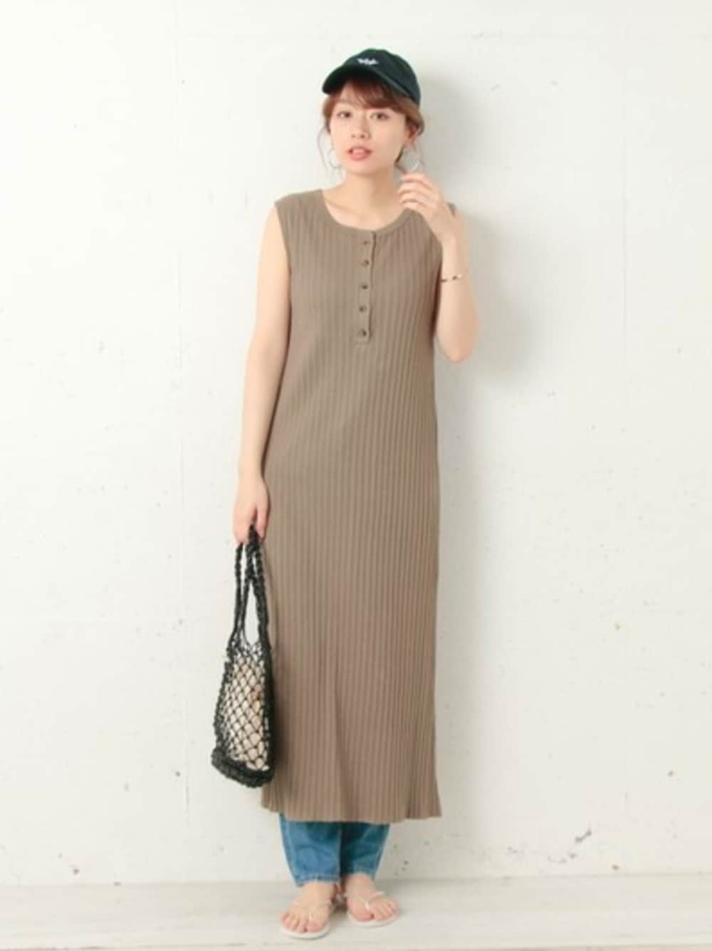 グリーン系のワンピース、ブルー系のデニムパンツ、ホワイト系のサンダルを着用したレディースの春コーディネートの1枚目の写真