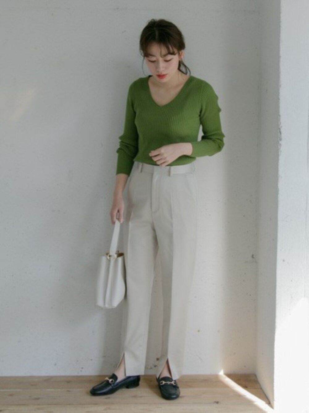 グリーン系のニット/セーター、ホワイト系のショルダーバッグ、ブラック系のローファーを着用したレディースの冬コーディネートの1枚目の写真