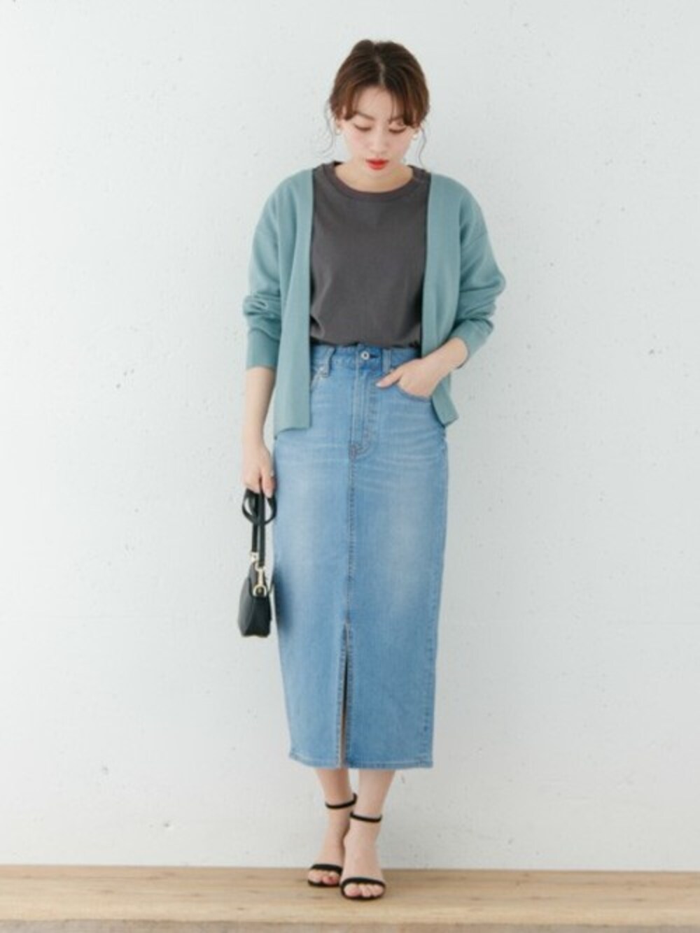 グレー系のTシャツ/カットソー、ブルー系のカーディガン/ボレロ、ブルー系のデニムスカートを着用したレディースの冬コーディネートの1枚目の写真