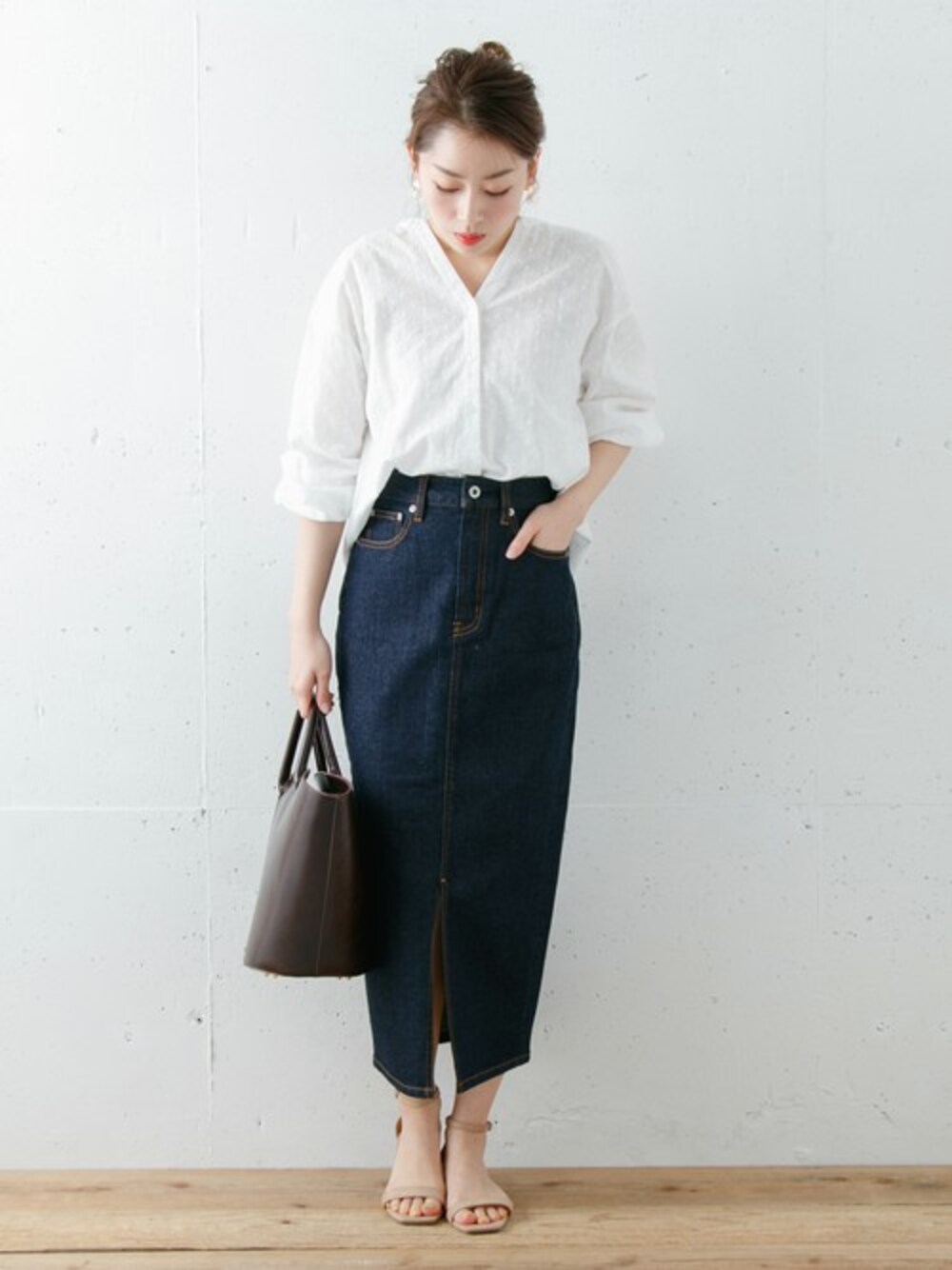 ブルー系のデニムスカート、ホワイト系のシャツ/ブラウスを着用したレディースの冬コーディネートの1枚目の写真