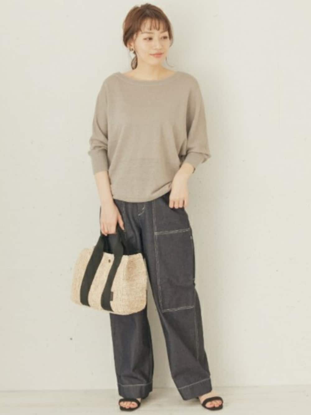ベージュ系のニット/セーター、ブラック系のサンダルを着用したレディースの春コーディネートの1枚目の写真