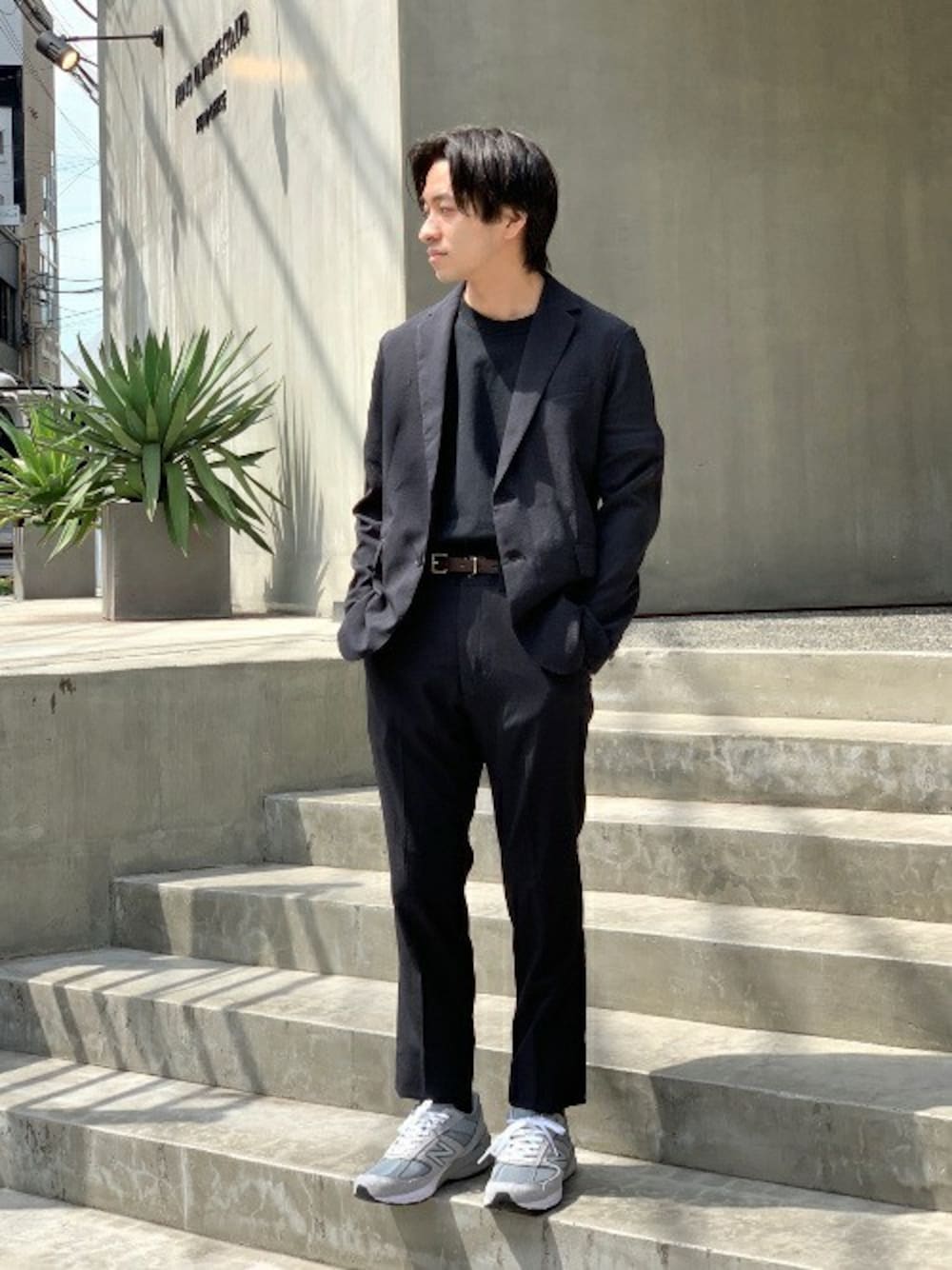 ブラック系のテーラードジャケット、ブラック系のTシャツ/カットソー、グレー系のスニーカーを着用したメンズの春コーディネートの1枚目の写真