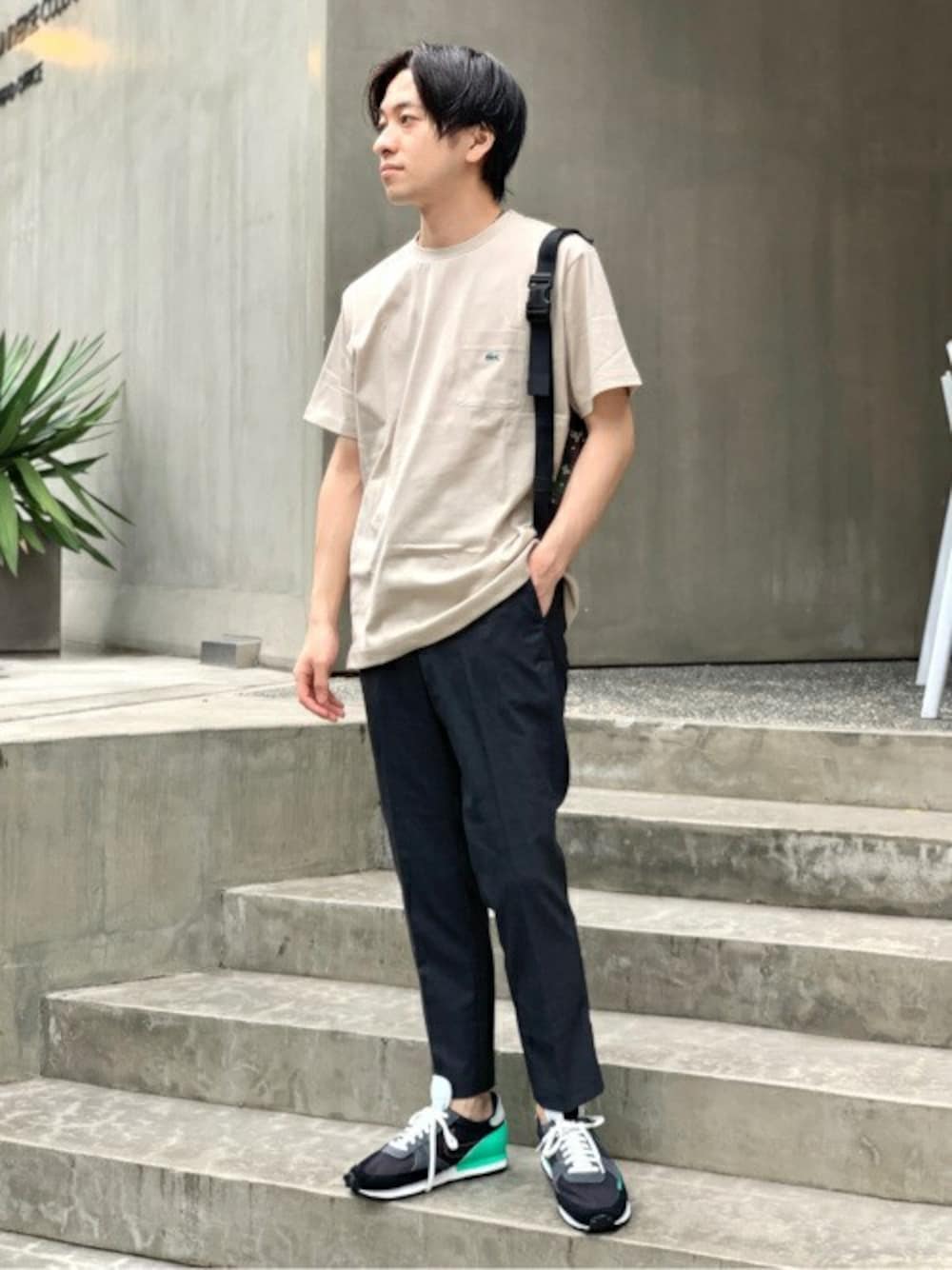 ベージュ系のTシャツ/カットソー、ブルー系のスラックス、グレー系のボディバッグ/ウエストポーチを着用したメンズの夏コーディネートの1枚目の写真