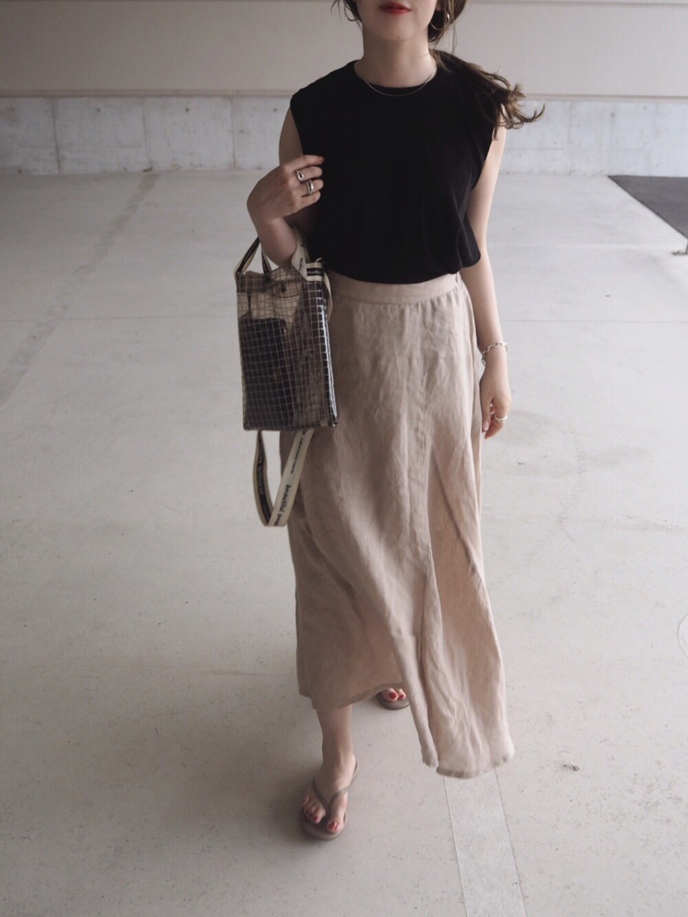 ブルー系のTシャツ/カットソー、ベージュ系のスカート、ブラック系のショルダーバッグを着用したレディースの夏コーディネートの1枚目の写真
