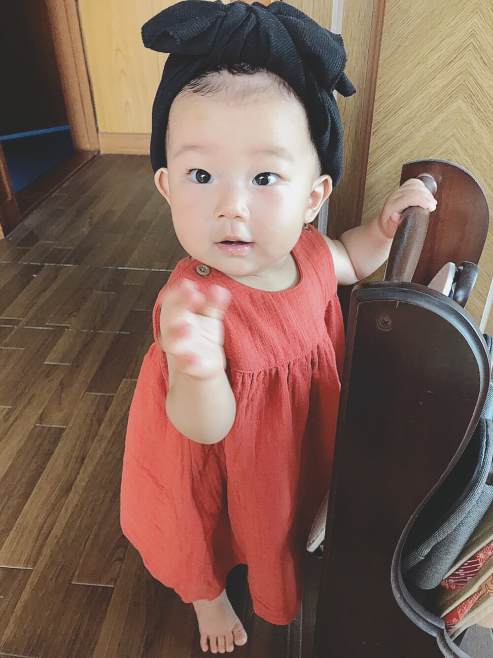 オレンジ系のワンピース、ブラック系のヘアバンド、オレンジ系のその他を着用したキッズの夏コーディネートの1枚目の写真