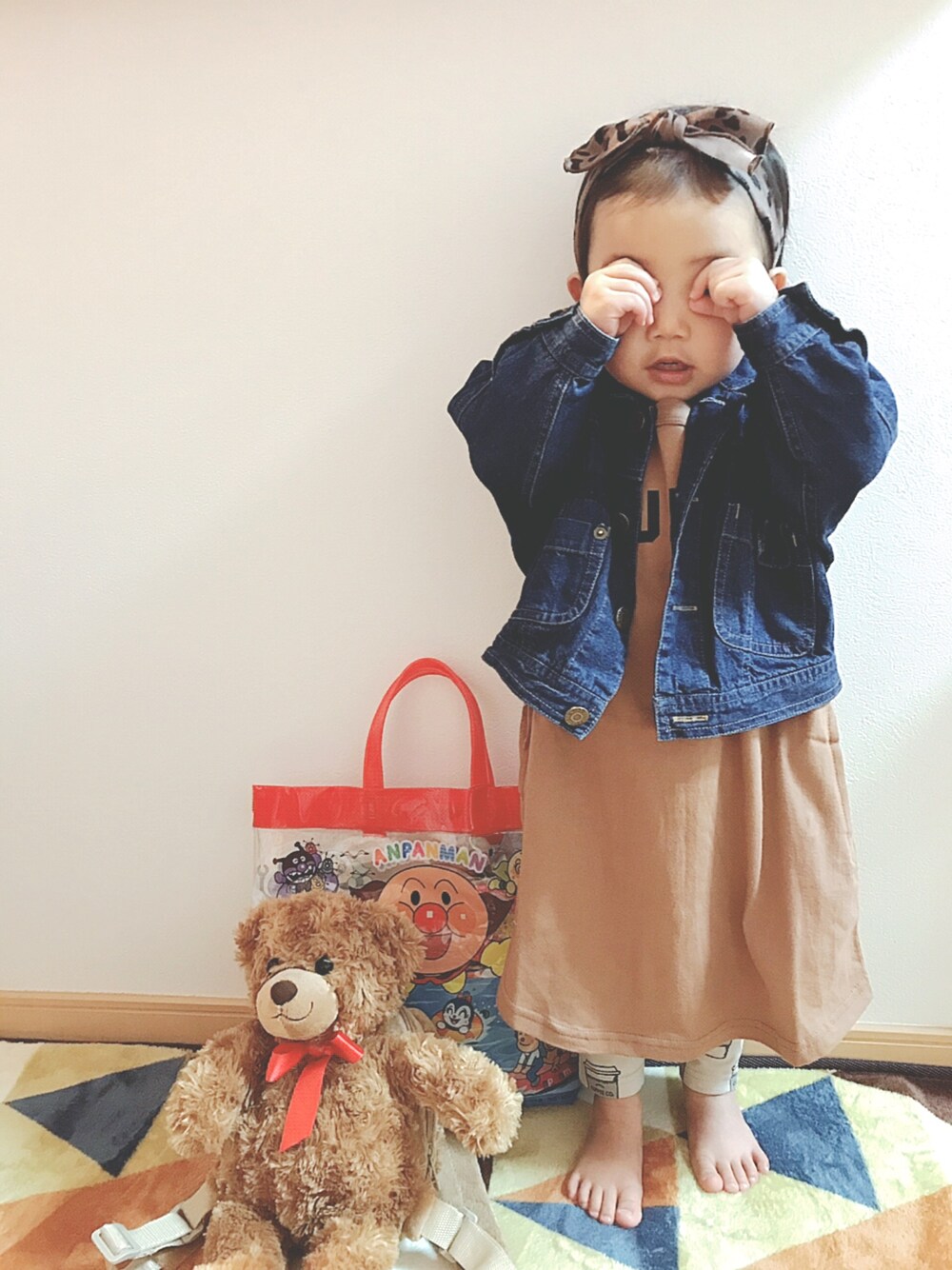 ブルー系のデニムジャケット、ブラウン系のワンピース、ベージュ系のその他パンツを着用したキッズの春コーディネートの1枚目の写真