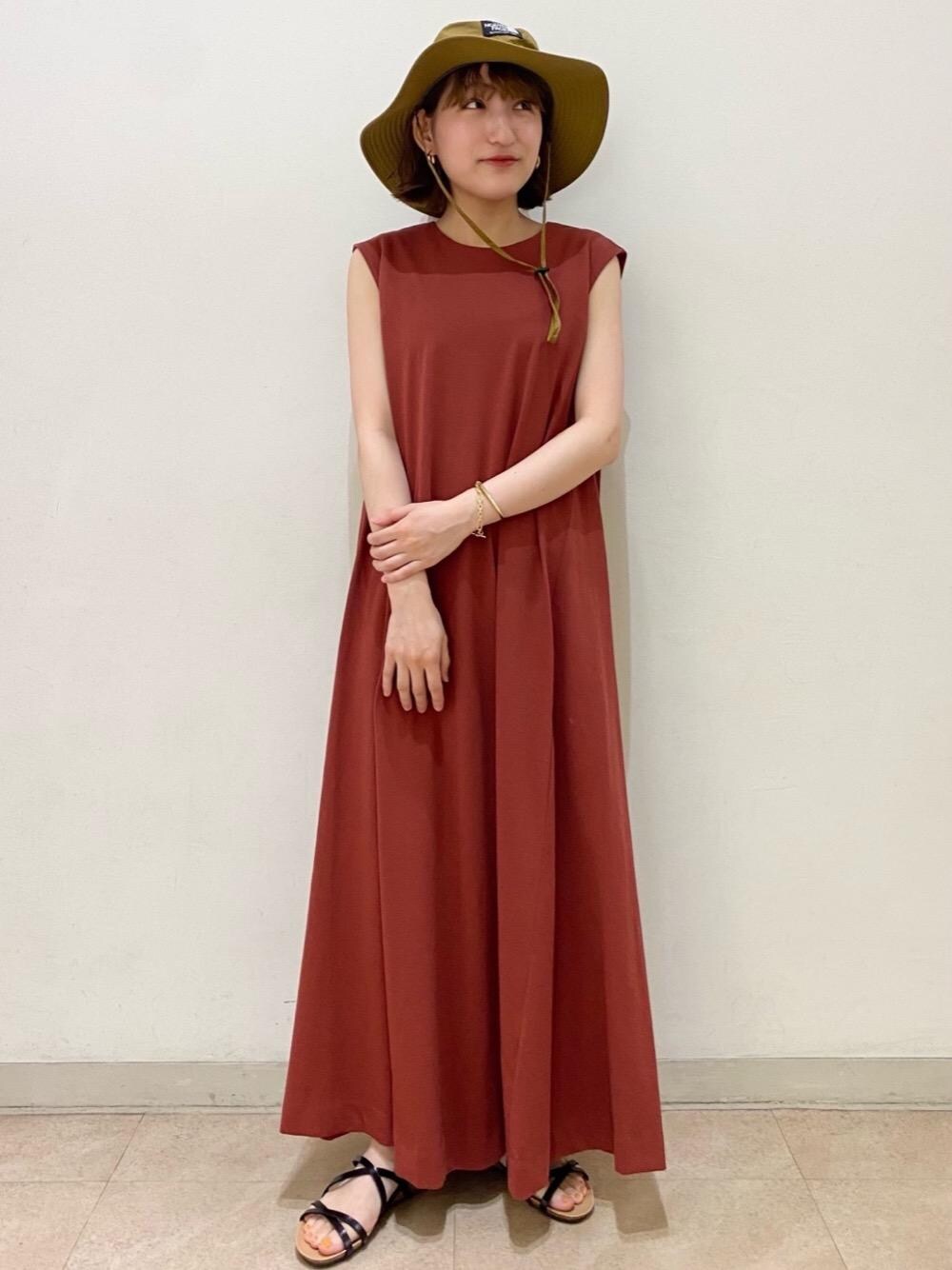 ブラック系のサンダル、オレンジ系のワンピース、ゴールド系のブレスレットを着用したレディースの夏コーディネートの1枚目の写真