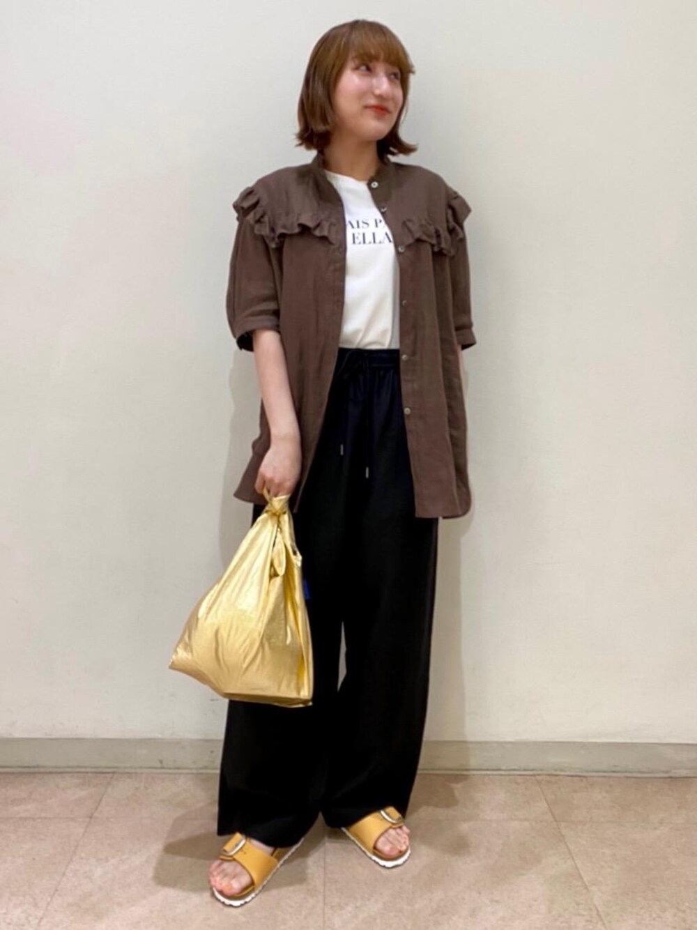 ブラック系のその他パンツ、ホワイト系のTシャツ/カットソー、ゴールド系のエコバッグ/サブバッグを着用したレディースの夏コーディネートの1枚目の写真