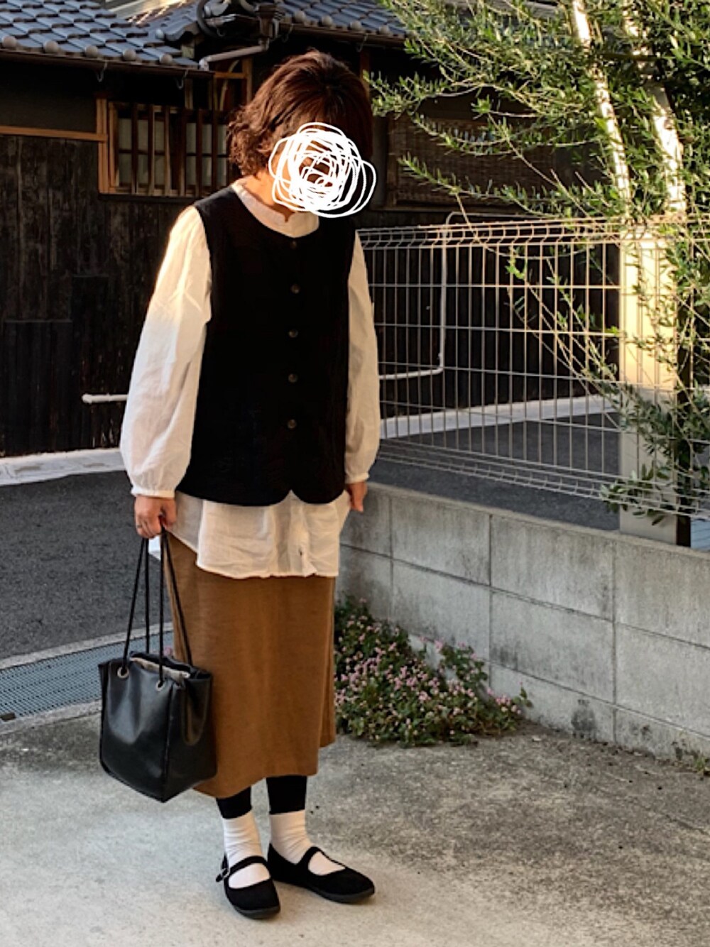 ブラック系のベスト、ホワイト系のシャツ/ブラウス、ブラック系のバレエシューズを着用したレディースの秋コーディネートの1枚目の写真