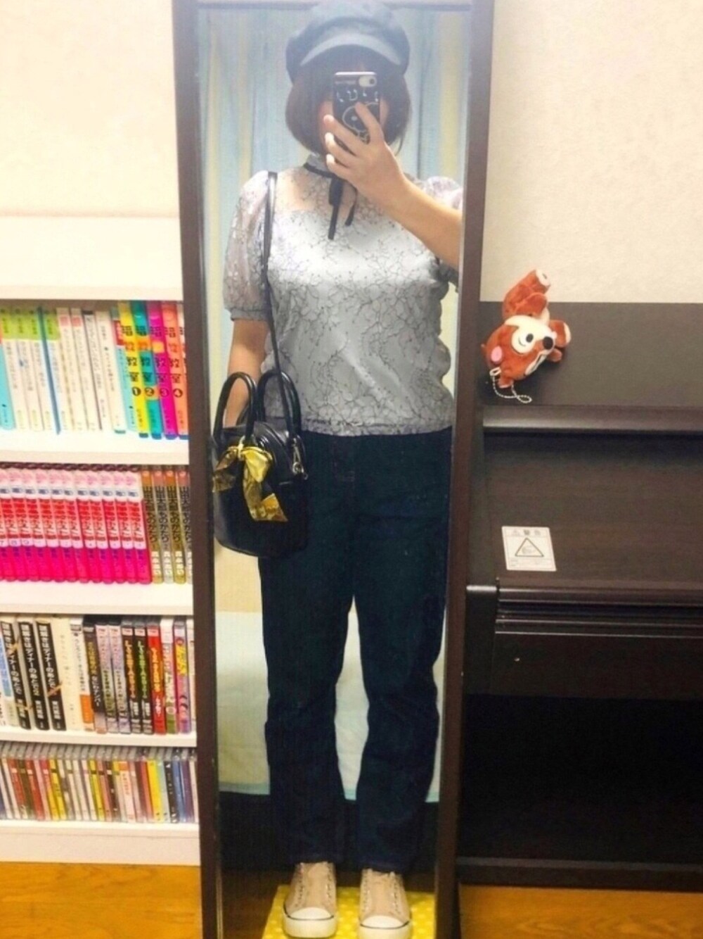 グレー系のトップス、ベージュ系のスニーカー、ブラック系のショルダーバッグを着用したレディースの秋コーディネートの1枚目の写真