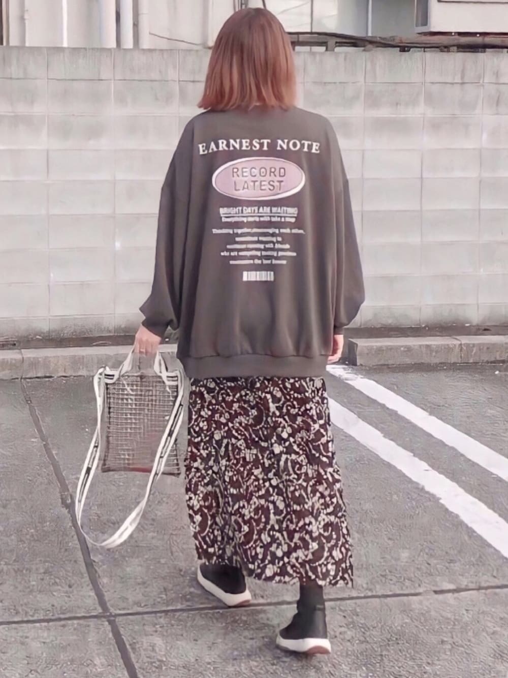ブラック系のTシャツ/カットソー、ブラック系のスカート、ブラック系のスニーカーを着用したレディースの秋コーディネートの1枚目の写真