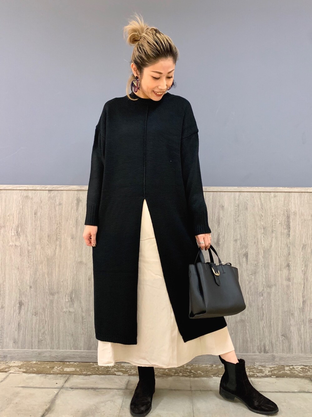 ブラック系のワンピース/ドレス、ベージュ系のスカート、ブラック系のバッグを着用したレディースの秋コーディネートの1枚目の写真
