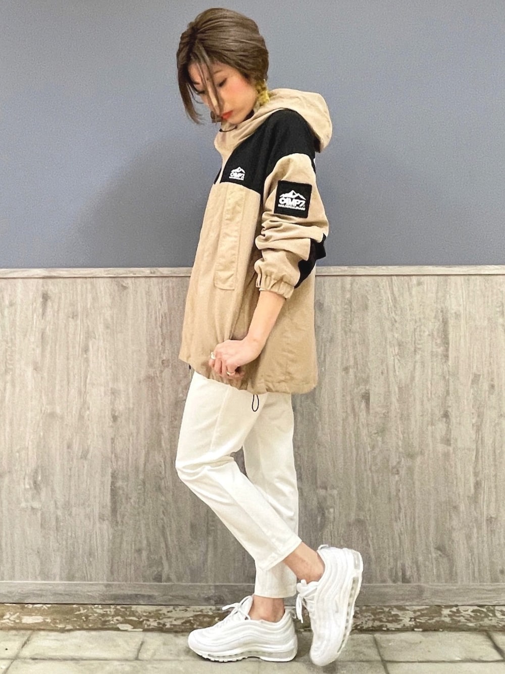 ベージュ系のマウンテンパーカー、ホワイト系のその他パンツ、ホワイト系のスニーカーを着用したレディースの冬コーディネートの1枚目の写真
